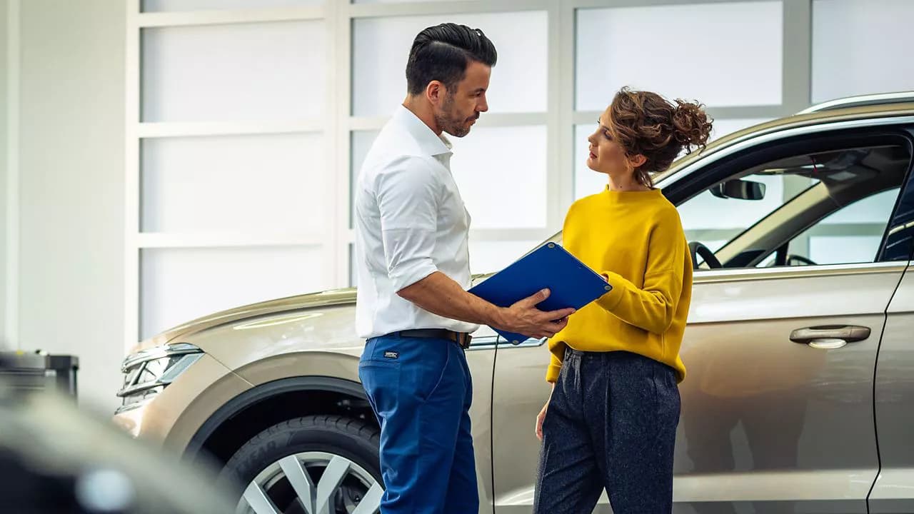 Una persona muestra una carpeta con documentos a otra persona